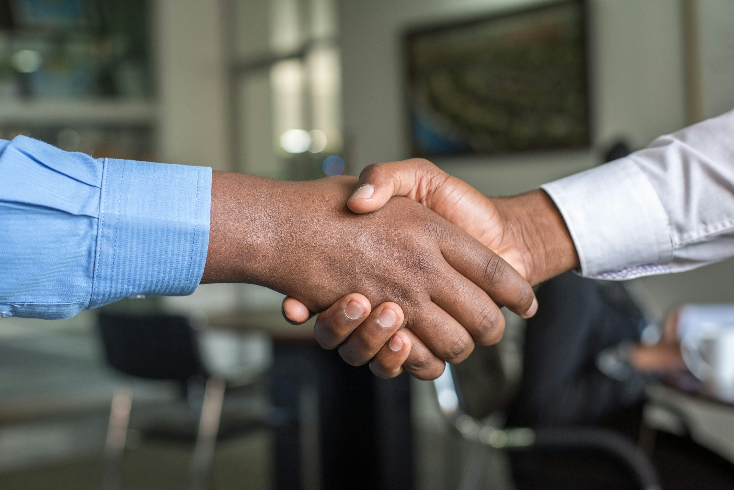 Two businesspeople shaking hands on a funding deal in a Nairobi office