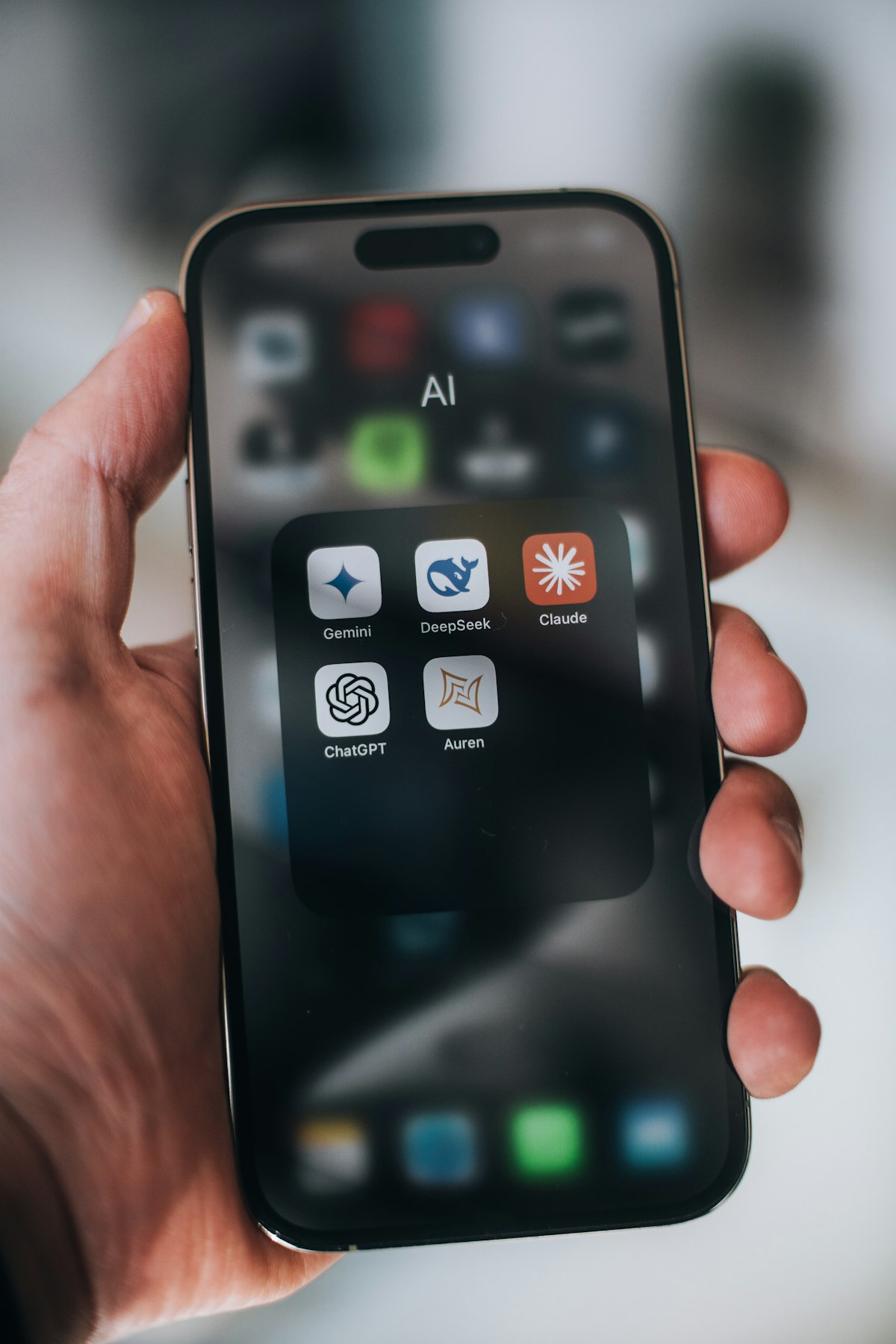 Smartphone home screen showing AI assistant apps like Gemini, Claude, and ChatGPT