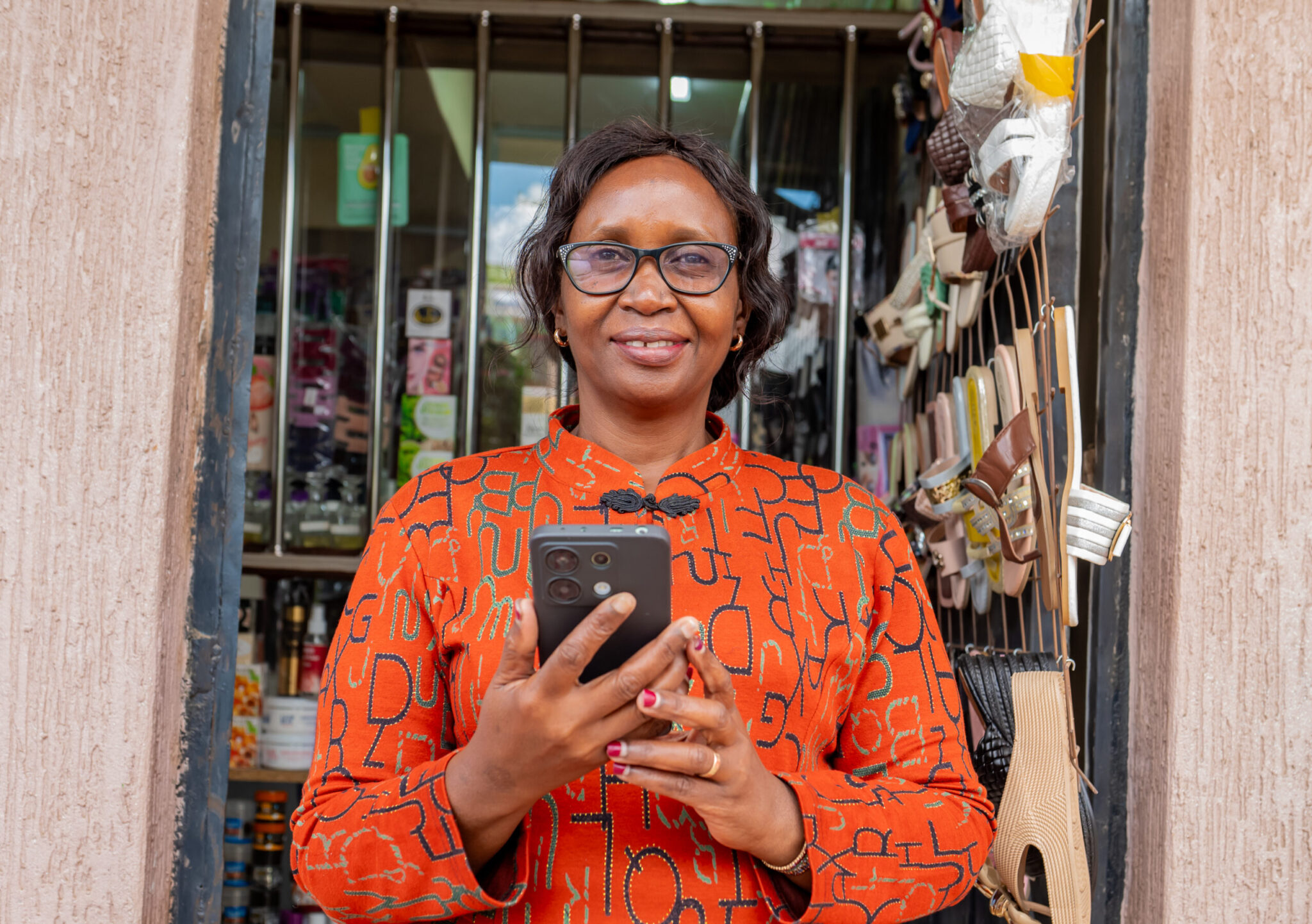 Entrepreneur in Nairobi using a phone for business, representing African business owners adopting AI tools