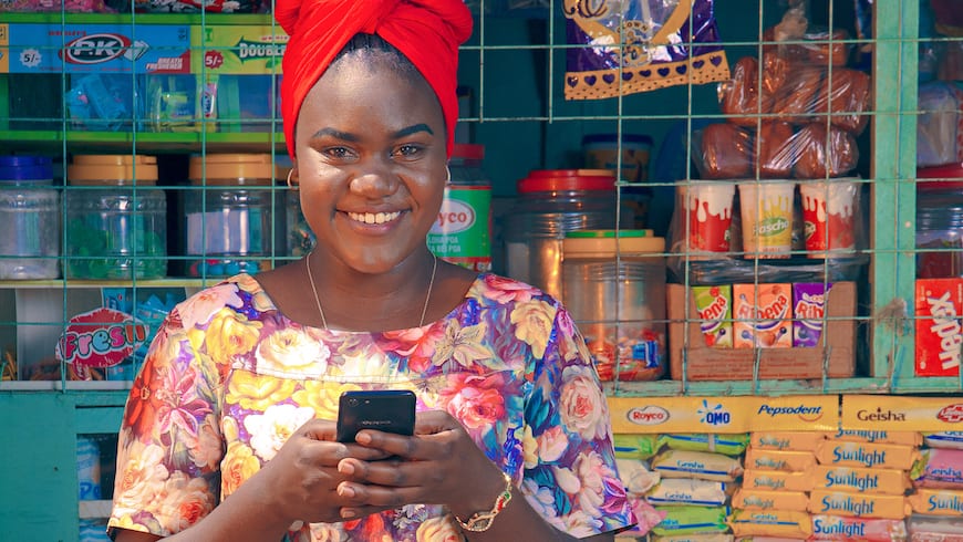 Small shop owner using technology at the counter of her business