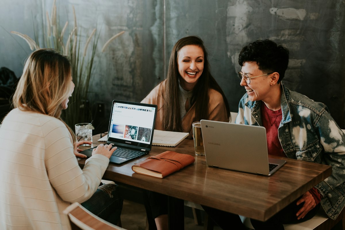 Group of young creators collaborating on digital content with laptops