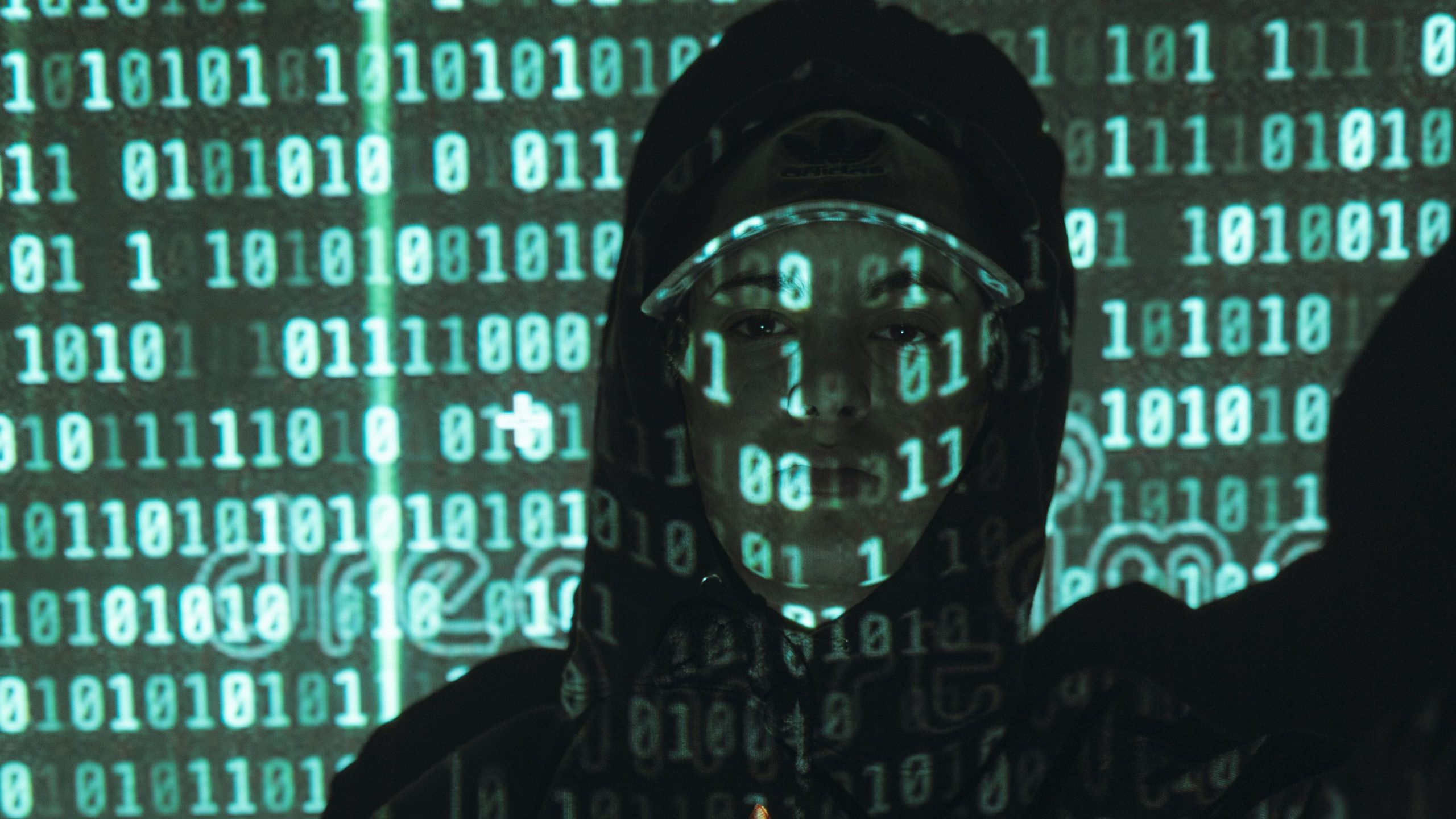 Cybersecurity specialist monitoring code on multiple screens